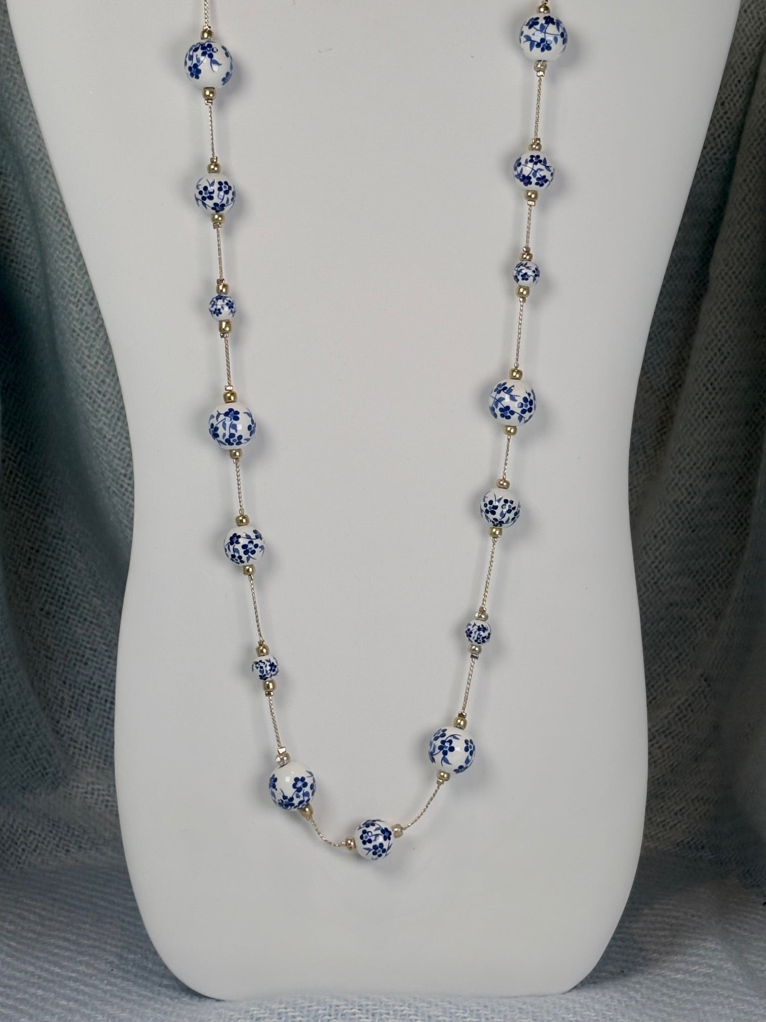 33 inch gold tone necklace with white and blue cottage core beads